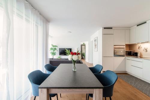 洛迦诺Linda Terrace by Quokka 360 - modern one-bedroom flat with sun terrace的一张带蓝色椅子和花瓶的餐桌