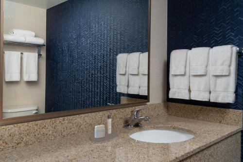 ShalimarFairfield by Marriott Fort Walton Beach-Eglin AFB的浴室配有盥洗盆、镜子和毛巾