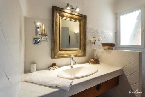 维琪奥港Hôtel Palombaggia的一间带水槽和镜子的浴室