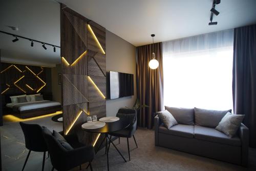 BokhonikiHIDE PARK HOTEL的客厅配有沙发和桌椅