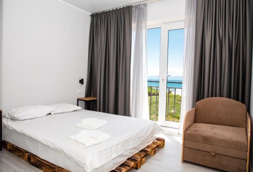 乔尔蓬阿塔Silence hotel的卧室配有床、椅子和窗户。