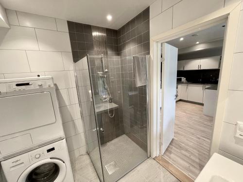 卑尔根Apartment Lilletveitvegen的带淋浴和洗衣机的浴室