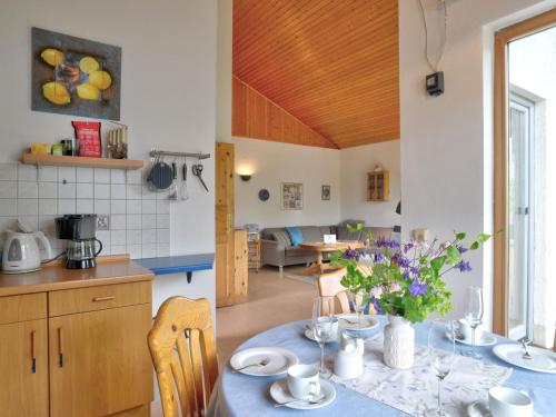 乌斯拉尔Holiday Home Feriendorf Uslar-1 by Interhome的厨房以及带鲜花桌的用餐室。