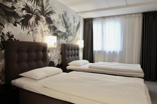 奥斯陆Super Stay Hotel, Oslo的配有白色床单的酒店客房内的两张床