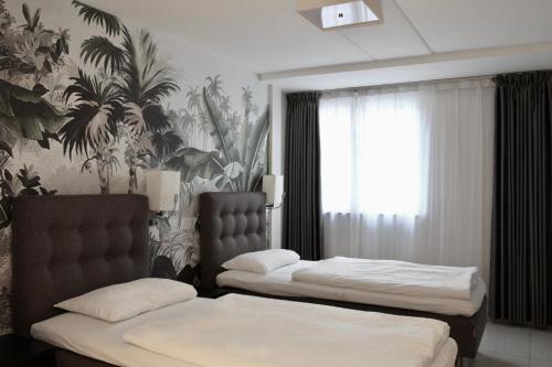 奥斯陆Super Stay Hotel, Oslo的一间卧室设有两张床和热带壁纸
