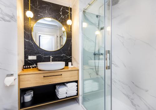 克拉科夫Bentis Luxury Apartments的带淋浴、盥洗盆和镜子的浴室