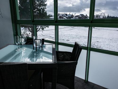 迪蒂斯豪森Apartment F 96 by Interhome的一张带酒杯的桌子,享有雪景