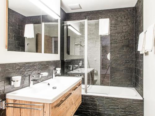 英格堡Apartment TITLIS Resort 2-Zimmer Wohnung 11 by Interhome的浴室配有水槽、淋浴和浴缸。