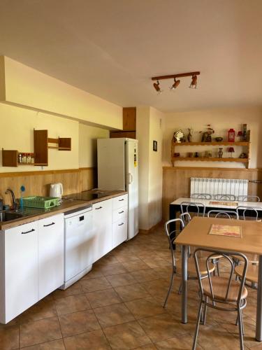 拉布卡Willa Światowid的厨房配有白色橱柜和桌子