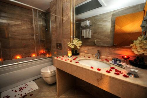 阿达纳金色豪华酒店的一间带水槽、卫生间和蜡烛的浴室