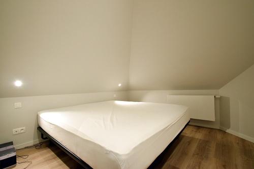 德哈恩De Torre的一间位于角落的带白色床的卧室
