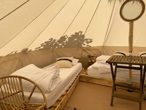 贝尼卡西姆Camping Tauro的帐篷配有两张床、一张桌子和一把椅子