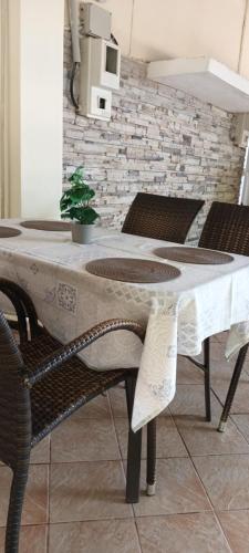 帕拉西亚斯Akrogiali Apartments的桌椅和白色桌布