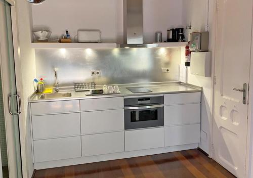 巴塞罗那Barceloneta Suites Apartments Beach的厨房配有水槽和炉灶
