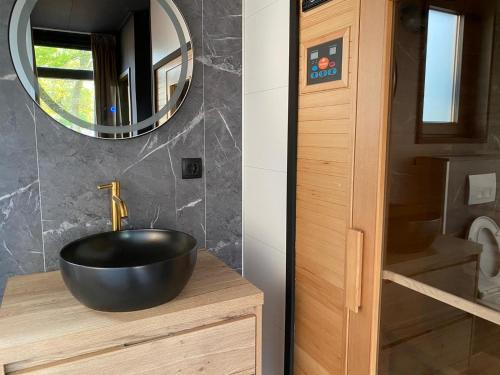 DalerveenWellnesslodge Specht的浴室设有黑色碗水槽和镜子