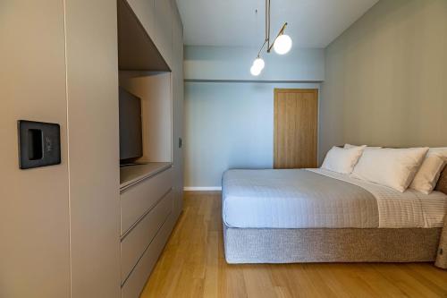 塞萨洛尼基ICONIC SALONICA SUITE seafront的一间卧室配有一张床和一台平面电视