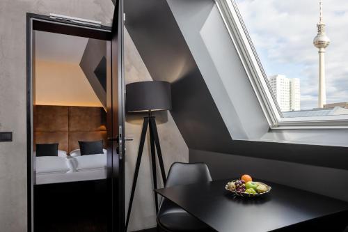 柏林Hotel ZOE by AMANO的客房设有桌子、窗户和床。