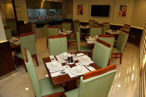 多哈Grand Legacy Hotel Doha的用餐室配有桌椅和餐具