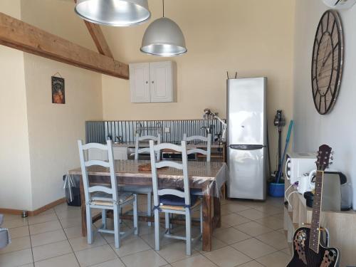 ArgeliersCanal du Midi Argeliers Gîte 4 personnes的厨房配有桌椅和冰箱。