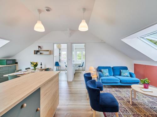 CroissanvilleApartment Le laizon 2 by Interhome的厨房以及带蓝色沙发的客厅。