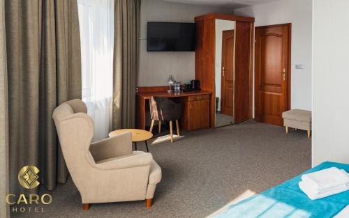 波兹南Hotel CARO的酒店客房配有椅子和书桌