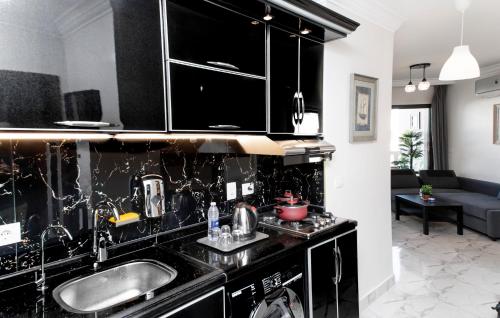 塞得港Porto Said Tourist Resort Luxury Hotel Apartment的厨房配有黑色橱柜和水槽
