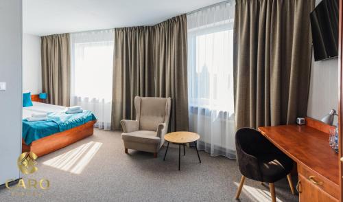 波兹南Hotel CARO的配有一张床和一张书桌的酒店客房