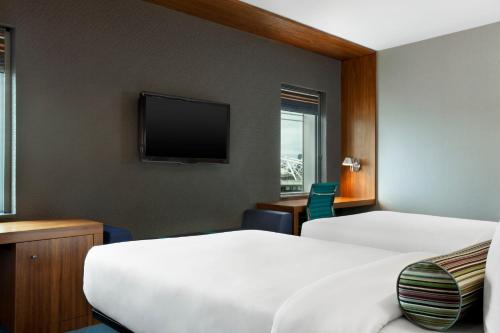 伦敦雅乐轩伦敦埃克塞尔酒店的酒店客房设有两张床和一台平面电视。