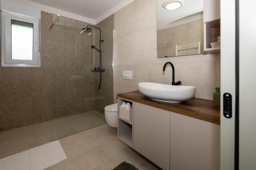 克尔克Villa Monika的一间带水槽、淋浴和卫生间的浴室
