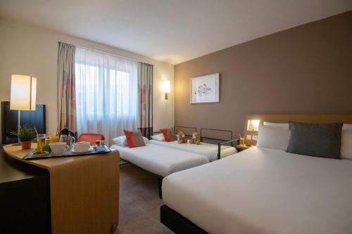 尼斯维尔尼斯诺富特尼斯中心酒店的酒店客房设有两张床和一张桌子。