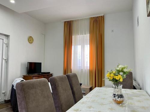 赫尔采格诺维Apartment Jovana的配有桌椅和花瓶的房间