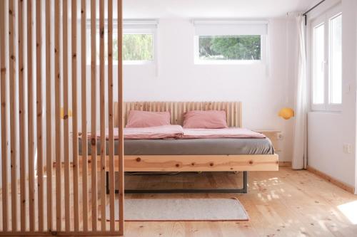 阿尔热祖尔Casa Mini & Casa Mia的一间卧室配有一张木架床