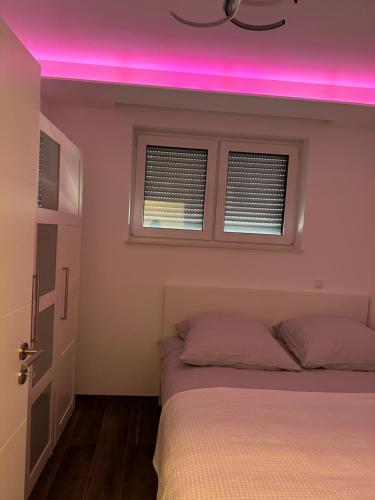 埃佩尔海姆myhouse.5的卧室配有粉红色的灯光,位于床上方