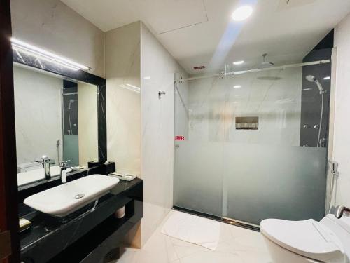 多哈Grand Legacy Hotel Doha的一间带玻璃淋浴和水槽的浴室