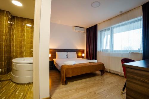 TunariiBliss Inn Tunari的酒店客房配有一张床和浴缸。
