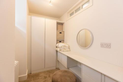 爱丁堡RÌGH Properties - Luxury West End Artisan Apartment的浴室设有白色橱柜和镜子