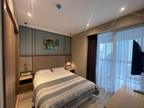巴统Paradise Apartments Batumi的一间卧室设有一张床和一个大窗户