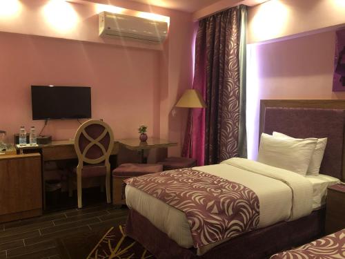 开罗开罗桑塔纳酒店的配有一张床和一张书桌的酒店客房