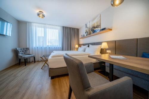 林道bodenseezeit Apartmenthotel Garni的配有一张床和一张书桌的酒店客房