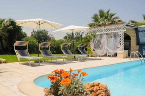 莫诺波利特奴塔马蒂内利住宿加早餐旅馆的毗邻度假酒店的带椅子和遮阳伞的游泳池