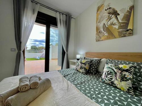 卡勒达德福斯特Casa Mae的卧室配有带枕头的床铺和窗户。