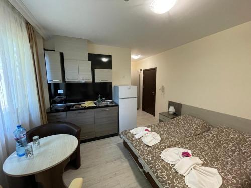索佐波尔辉煌公寓酒店 的配有床和桌子的房间以及厨房