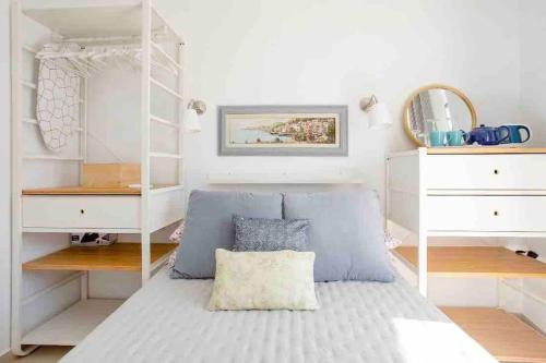 马萨尔福恩Little Blue House的卧室配有床和白色架子
