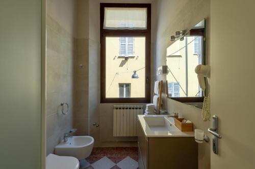 曼托瓦Ca' Tazzoli的一间带水槽和卫生间的浴室以及窗户。