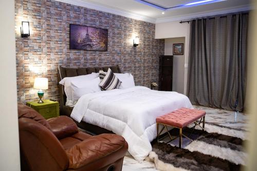 阿克拉Brynx Haven - Adenta, Accra的一间卧室设有一张床和砖墙