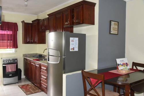 Spanish TownCozy and Secure Jacaranda Home的厨房配有不锈钢冰箱和桌子
