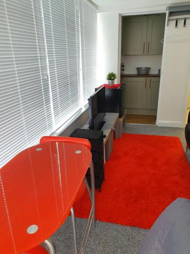 米尔顿凯恩斯Richfieldsat59的一间客厅,配有红色地毯和红色椅子