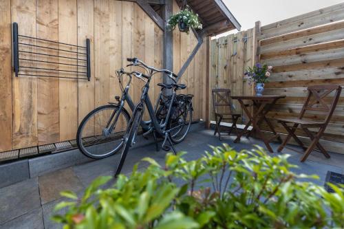 登堡Bed & Bike Schoudieck的自行车被锁在庭院的围栏上