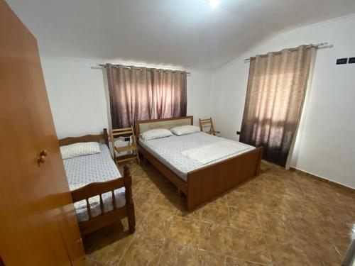 都拉斯Villa Osmani的一间卧室设有两张床和两个窗户。