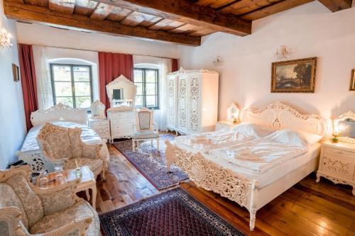 捷克克鲁姆洛夫莱拉里亚旅馆的卧室配有白色家具和一张大床